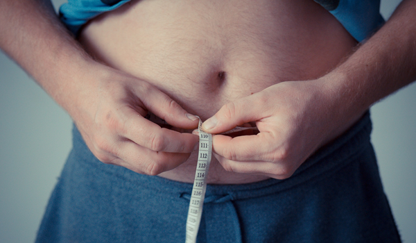 a person measuring their waist